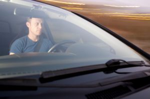 man sitting in the driver's seat of a car