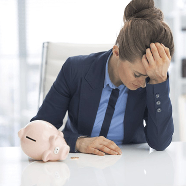 woman next to an empty piggy bank