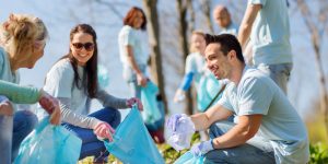 volunteers with garbage bags cleaning park area