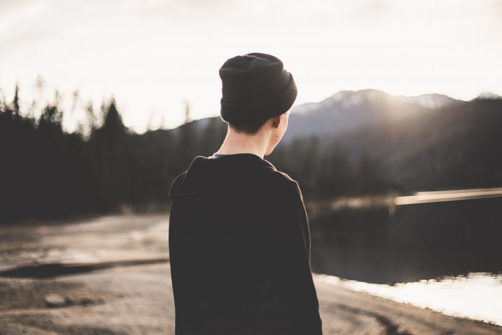 Man with beanie staring at mountains